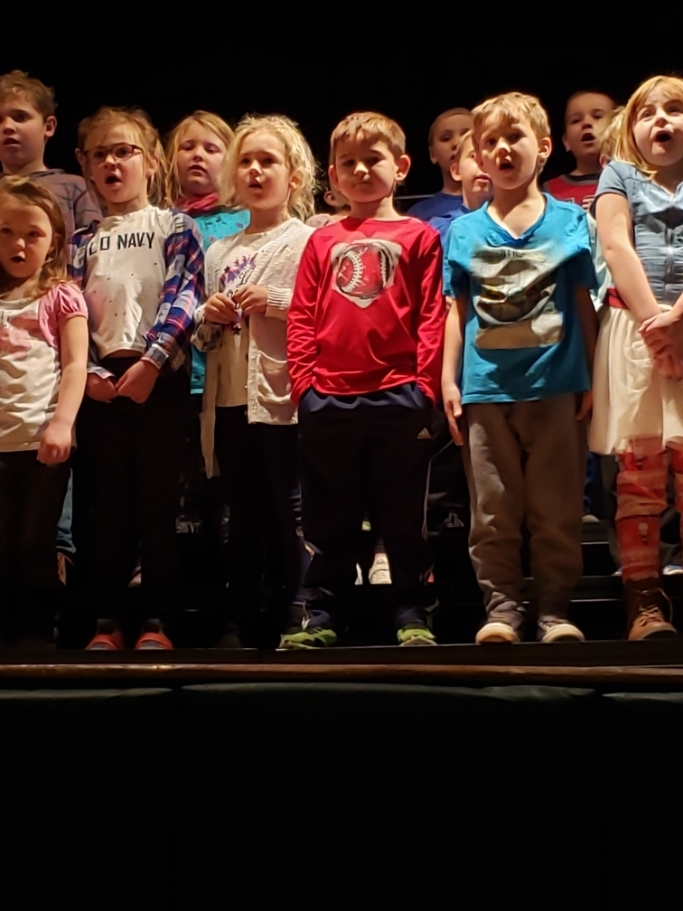 1st grade students singing at the assembly